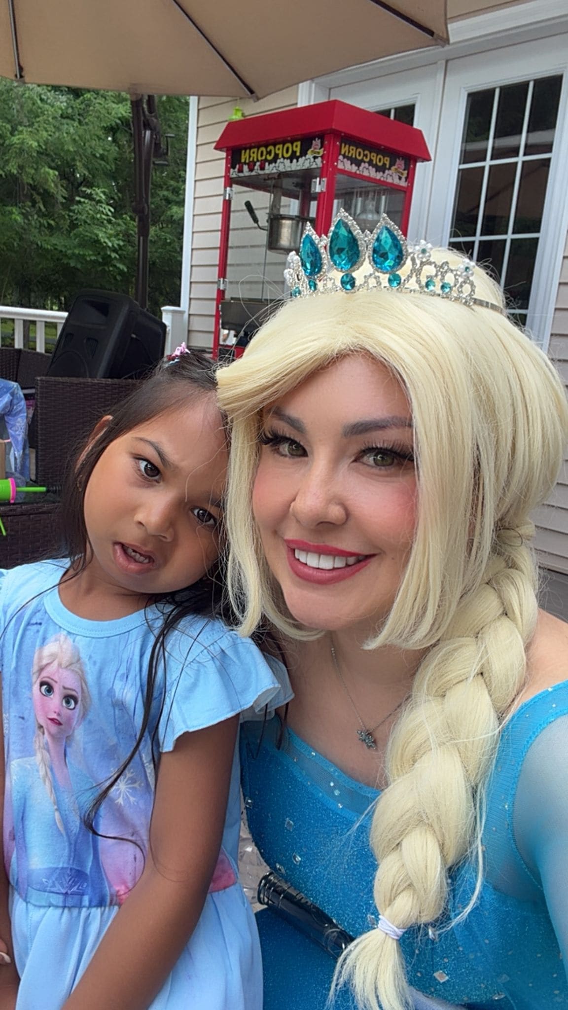 Costumed Frozen Elsa-style character performer with a child
