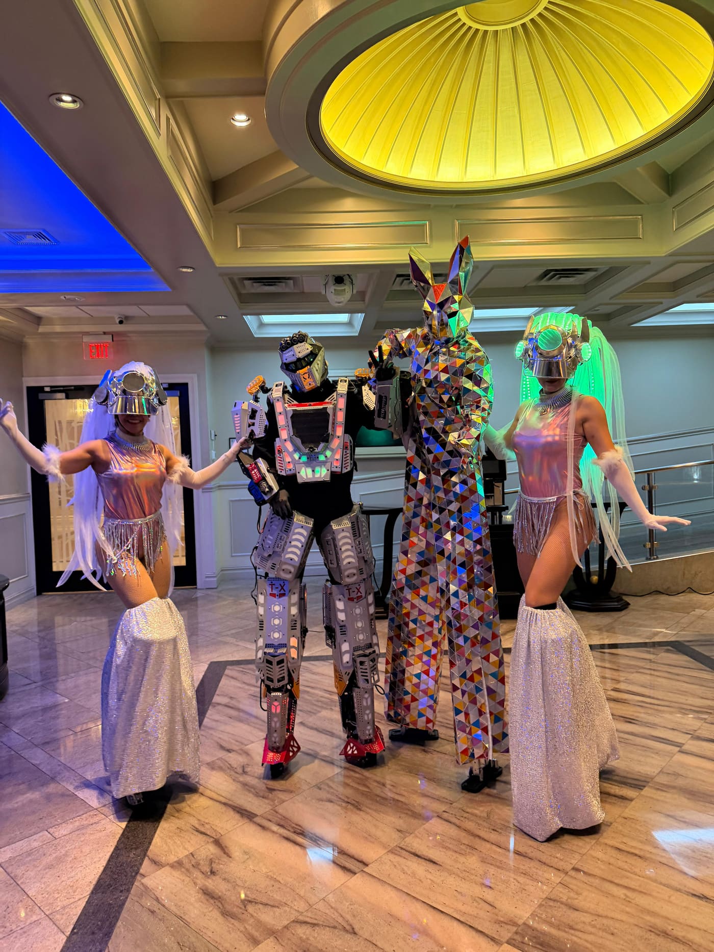 Hora loca performers with an LED robot and mirror-costume stilt walker