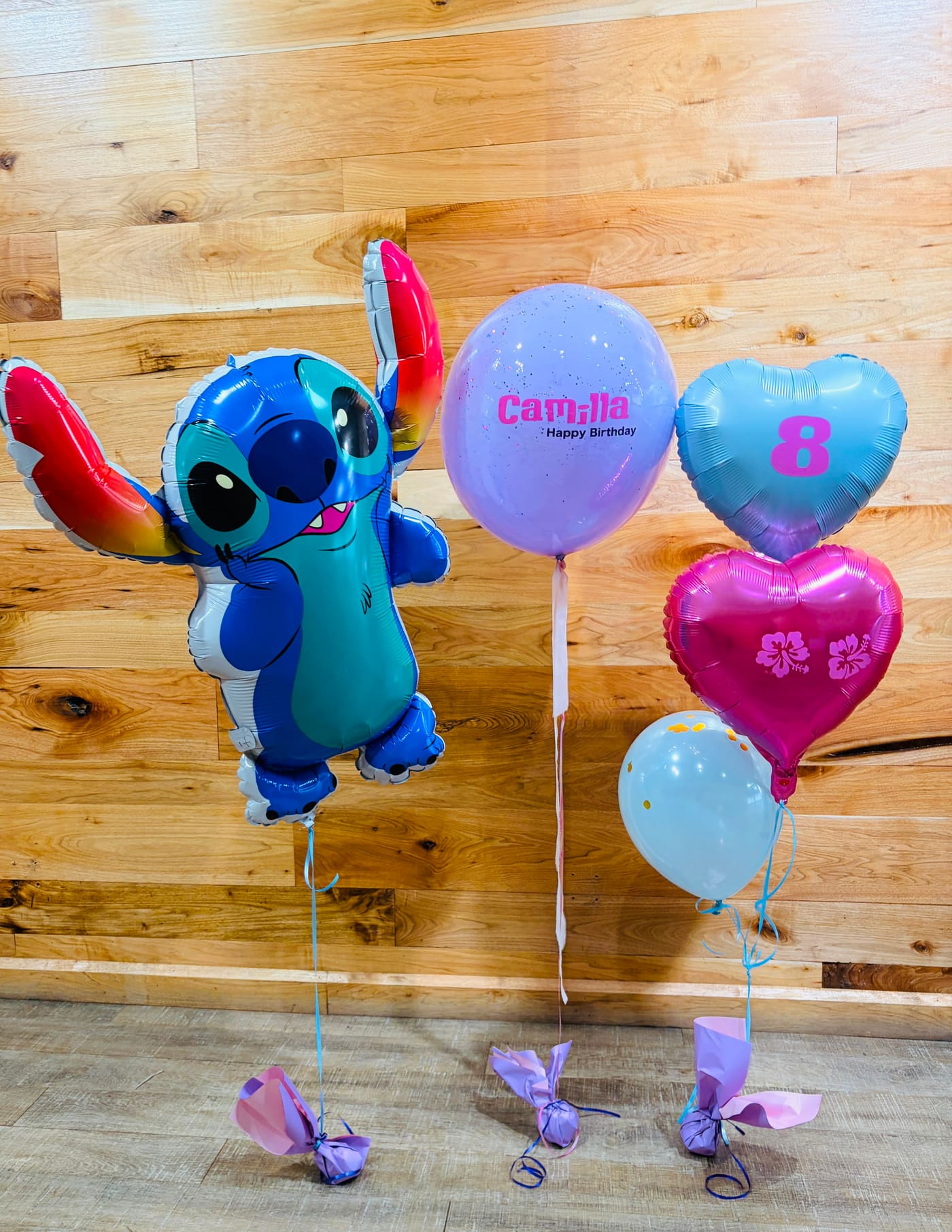 Stitch character balloon bouquet with heart-shaped foil balloons and a number balloon