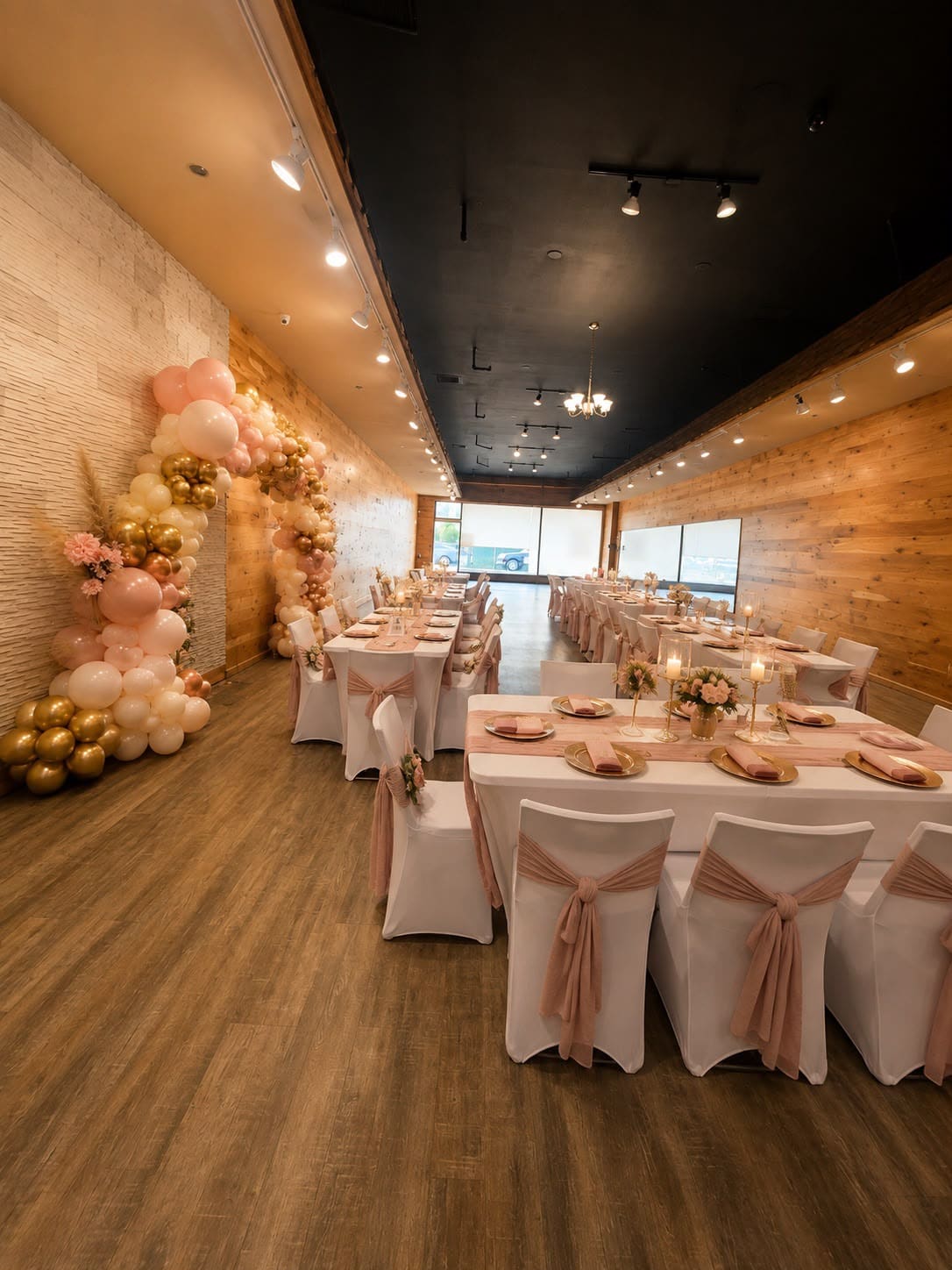 The Esme event venue in Union, NJ set with long tables and a blush and gold balloon arch